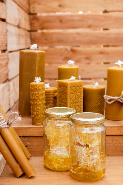 Una caja de madera con velas y un tarro de miel.