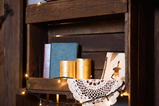 Foto caja marrón de madera que brilla intensamente con garland closeup velas doradas y libros antiguos