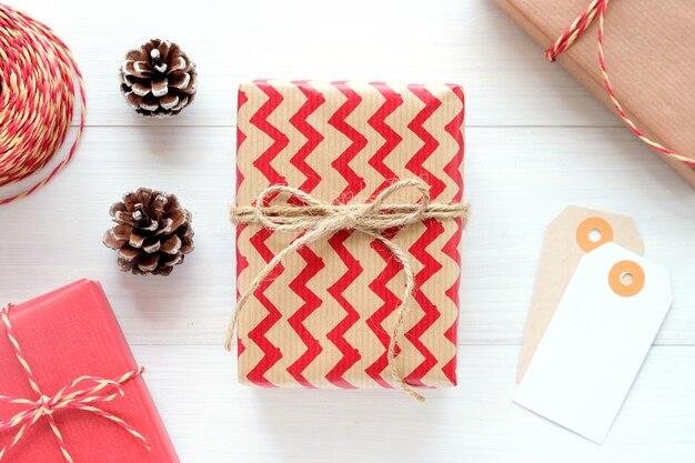 Caja y ornamento marrones y rojos de regalo del vintage en el fondo de madera blanco, fondo de la Navidad