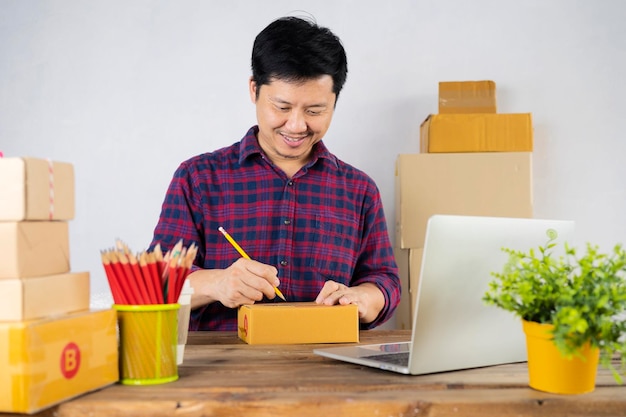 Caja de paquetes en el escritorio con un hombre haciendo notas en la parte de atrás