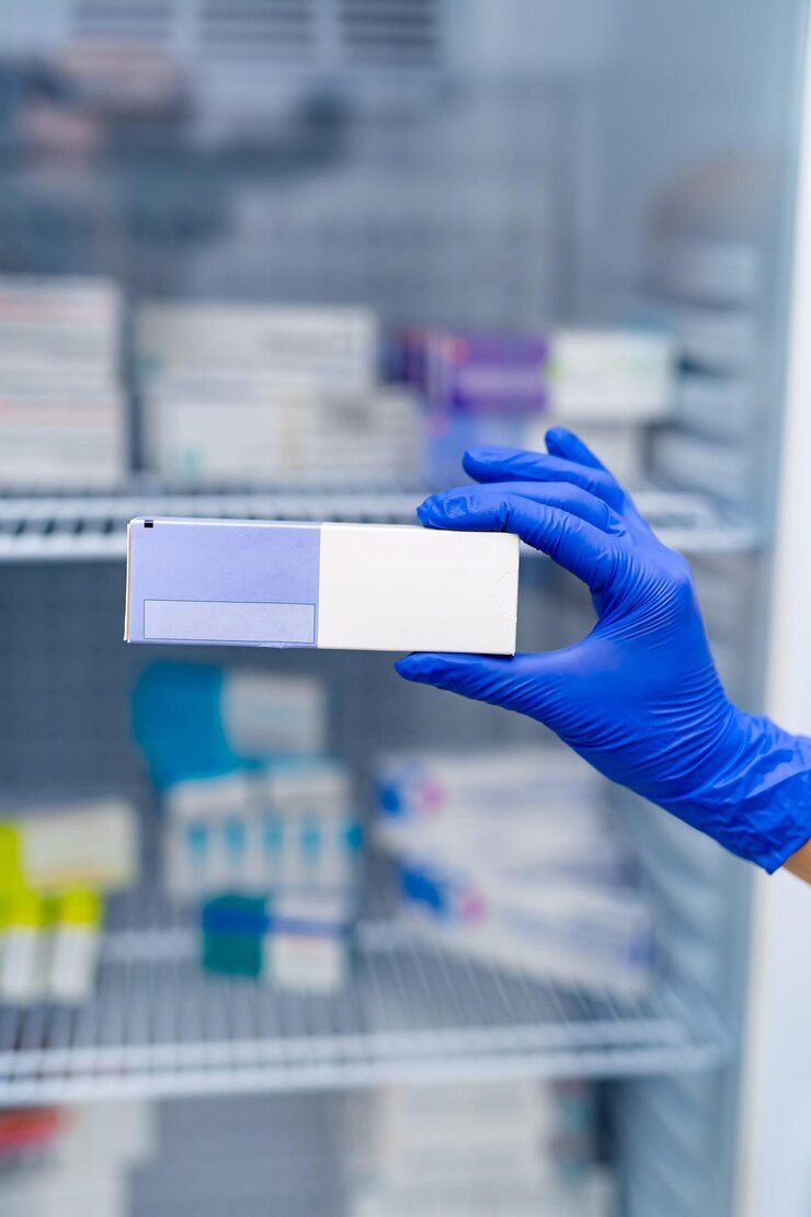 Caja de píldoras de farmacia y atención médica. Doctor mano en guante protector de goma azul con paquete de pastillas.