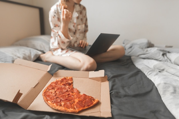 Caja de pizza caliente en una cama