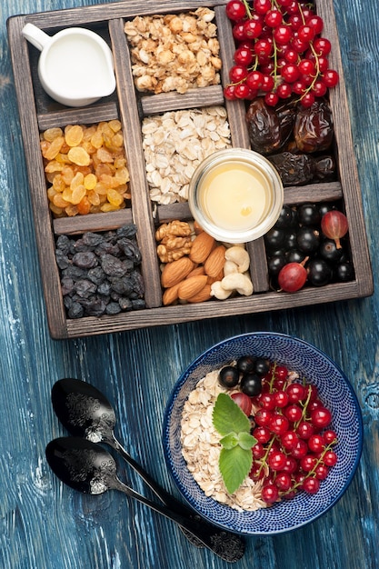 Caja con productos para un desayuno saludable Muesli avena frutos secos bayas frescas y nueces