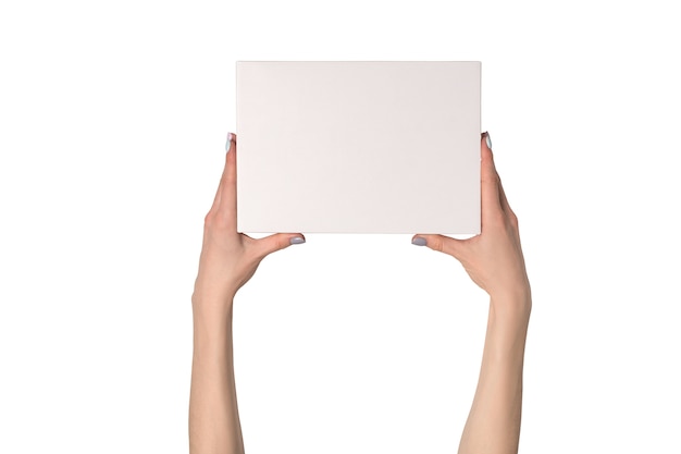 Caja rectangular blanca en manos femeninas