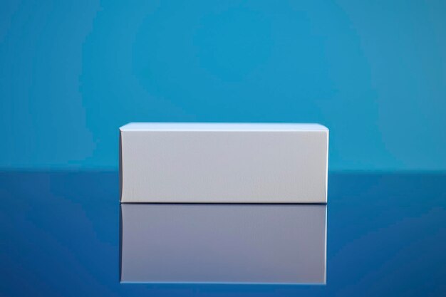 Caja rectangular blanca en una superficie reflectante azul