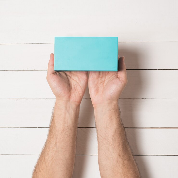 Foto caja rectangular turquesa en manos masculinas. vista superior.