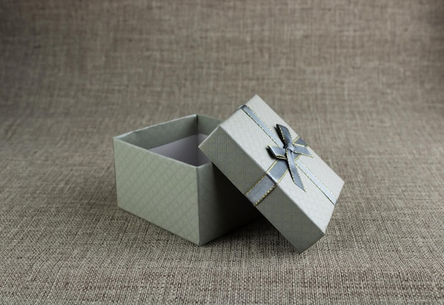 Caja de regalo abierta en gris sobre un fondo gris