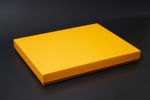 Caja de regalo amarilla sobre un fondo blanco.