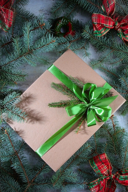 Foto caja con regalo para año nuevo la tapa de la caja está atada con cinta de raso verde