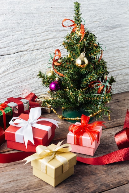 Caja de regalo con árbol de Navidad en el fondo de la mesa de madera