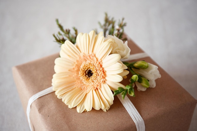 Caja de regalo artesanal con flores en la mesa