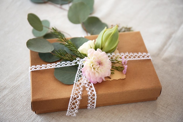 Caja de regalo artesanal con flores en la mesa