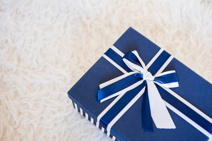 Caja de regalo azul y blanco con un bonito lazo, aislado en blanco.