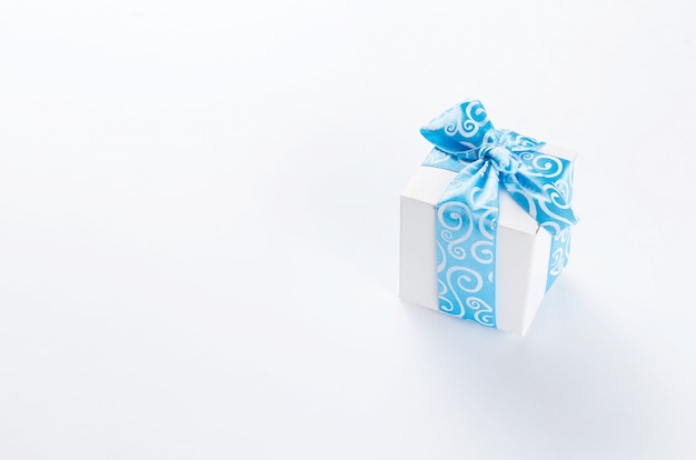 Caja de regalo blanca con lazo azul.