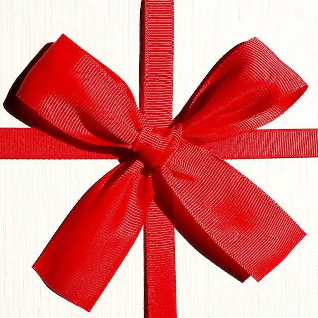 Foto caja de regalo blanca con lazo de cinta roja aislado sobre fondo blanco.