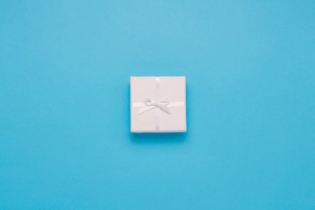 Caja de regalo blanca sobre un fondo azul. Estilo minimalista. Vista plana, vista superior