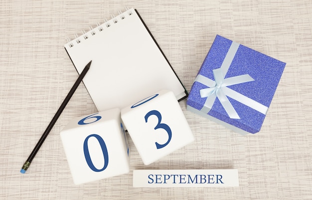 Caja de regalo y calendario de madera con números azules de moda, 3 de septiembre