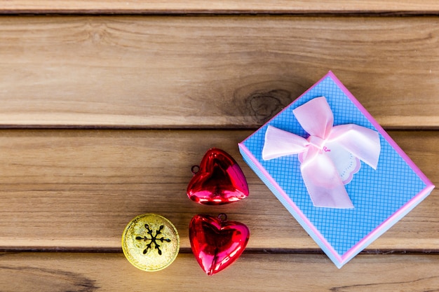 Foto caja de regalo y campana pequeña sobre fondo de madera