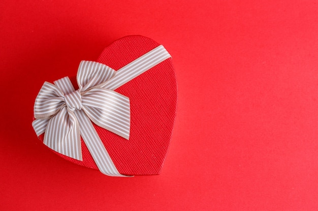 Caja de regalo de cartón biodegradable en forma de corazón con cintas en rojo