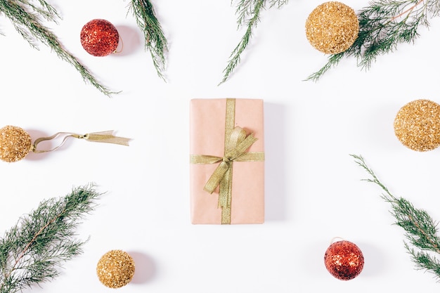 Caja con regalo y cinta dorada y adornos navideños