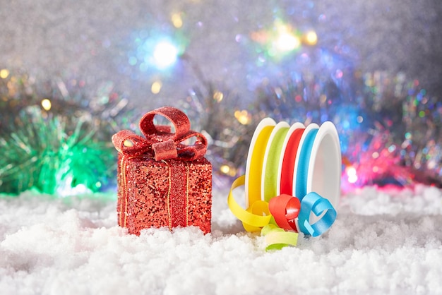 Una caja de regalo y una cinta de regalo en la nieve.