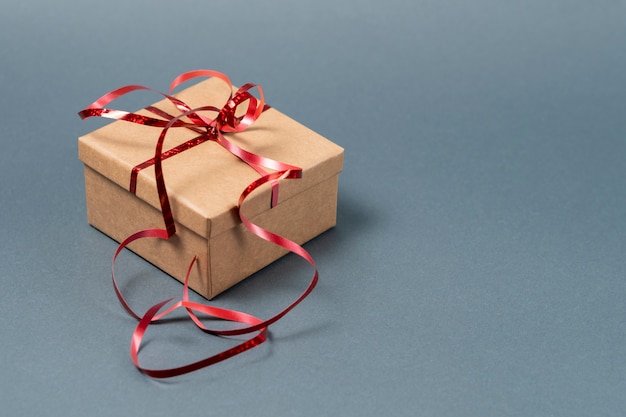 Caja de regalo con cinta roja sobre gris