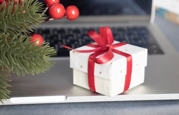 Caja de regalo con cinta roja sobre teclado portátil negro