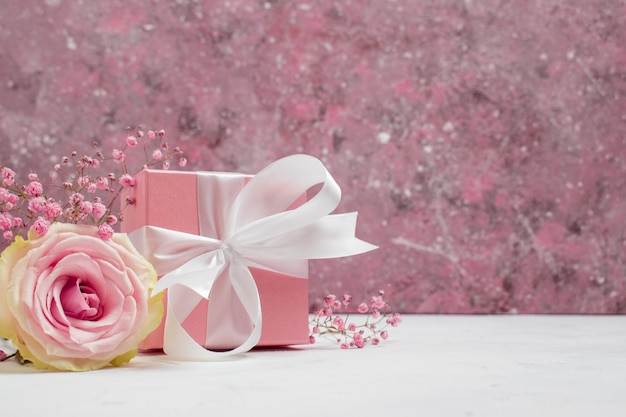 Caja de regalo con cinta rosa y fondo de gypsophila para el día de san valentín