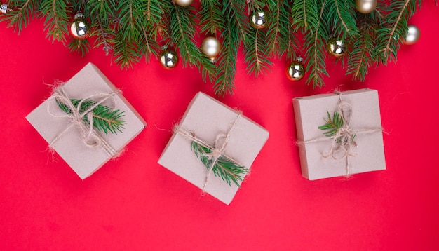 Caja de regalo con cinta sobre fondo de Navidad con ramas de abeto y bolas doradas, vista superior. Concepto de compras. Foto de alta calidad