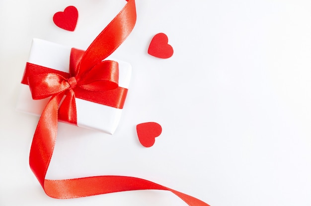 Caja de regalo y corazones de madera en blanco.