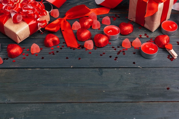 Caja de regalo con corazones rojos en mesa de madera