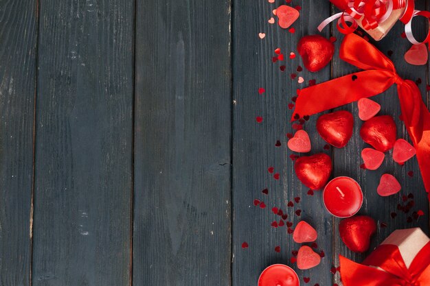 Caja de regalo con corazones rojos en mesa de madera