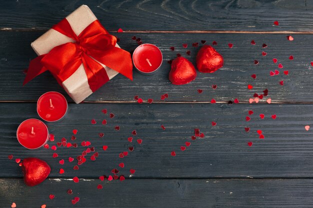 Caja de regalo con corazones rojos en mesa de madera