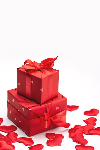 Caja de regalo y corazones rojos sobre un fondo claro