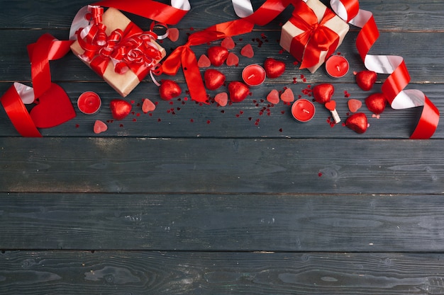 Caja de regalo con corazones rojos sobre fondo de mesa de madera