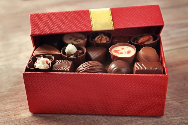 Caja de regalo con deliciosos dulces sobre fondo de madera