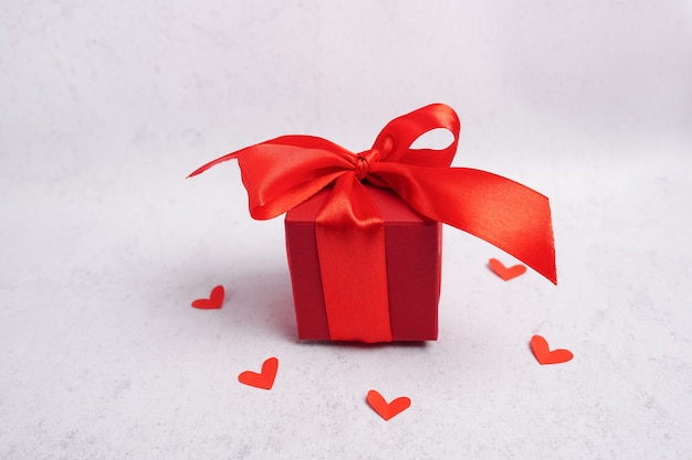 Caja de regalo del día de San Valentín, corazones y cinta sobre fondo gris