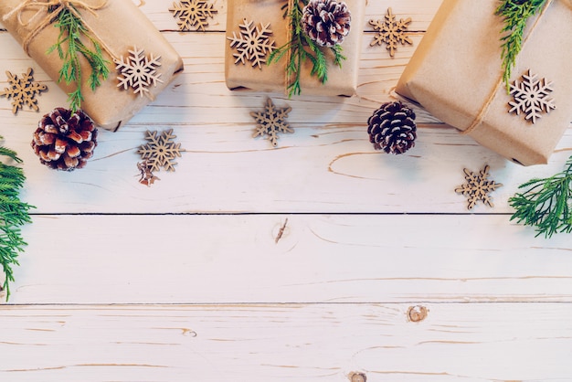 La caja de regalo envuelta hecha en casa de la Navidad presenta en un fondo de madera de la tabla con el espacio.