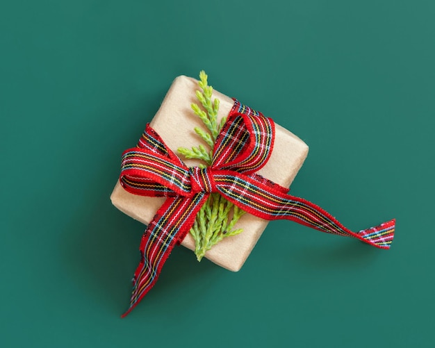 Caja de regalo envuelta en papel kart con lazo de cinta roja en la vista superior verde