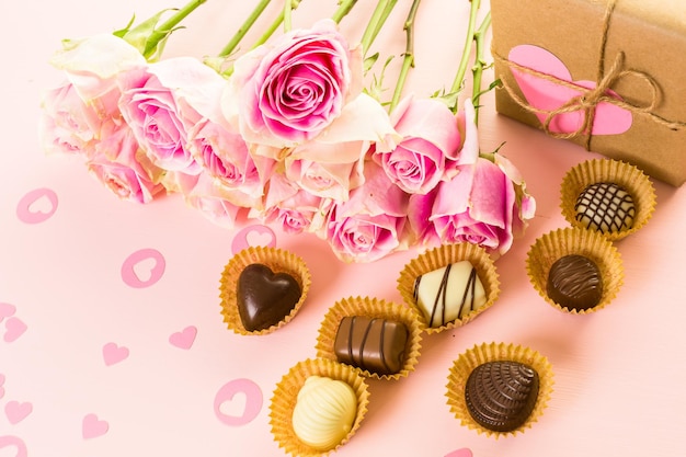 Caja regalo envuelta en papel reciclado y decorada con corazón rosa con rosas rosas.