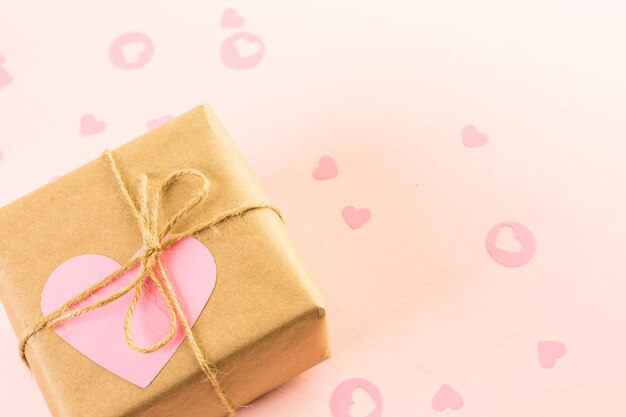 Caja regalo envuelta en papel reciclado y decorada con corazón rosa.