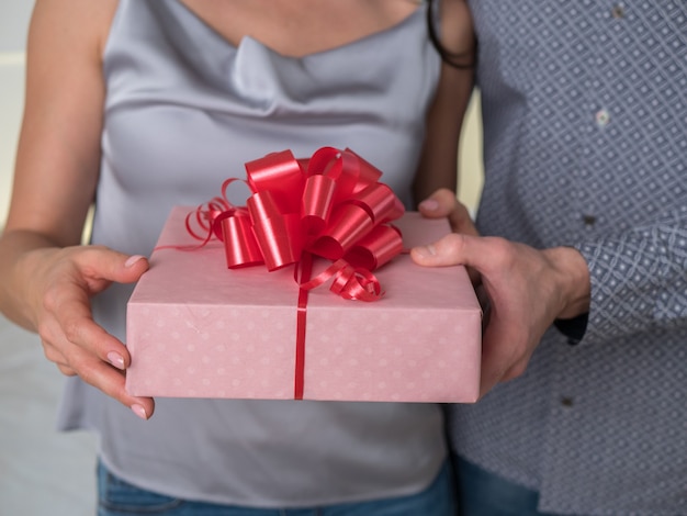 Caja de regalo familiar Manos masculinas y femeninas con caja roja