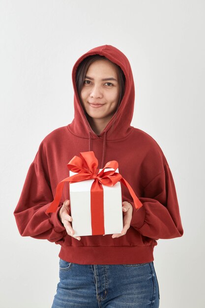 Caja de regalo feliz del control de la mujer joven en manos