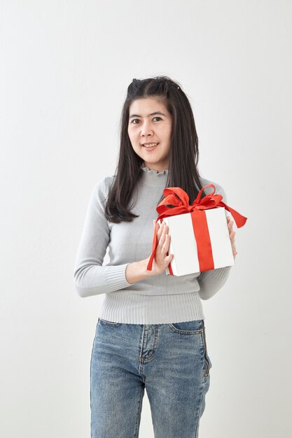 Caja de regalo feliz del control de la mujer joven en manos