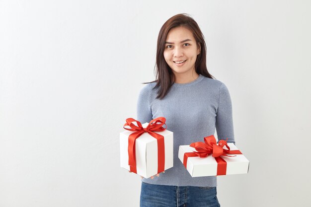 Caja de regalo feliz del control de la mujer joven en manos