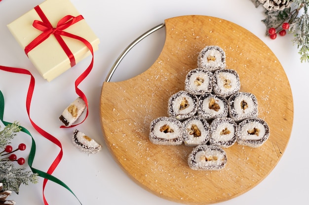 Caja de regalo festiva de Navidad y dulces con decoraciones de temporadas sobre fondo blanco.