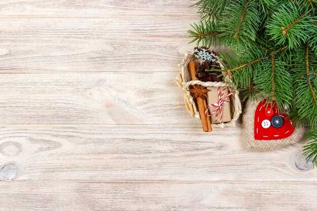 Caja de regalo festivo con corazón, anice estrellado, canasta, canela y copo de nieve sobre fondo de madera. Regalos de Navidad con copyspace