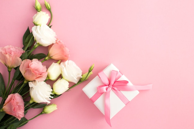 Caja de regalo, flores blancas y rosadas sobre fondo rosa con espacio de copia