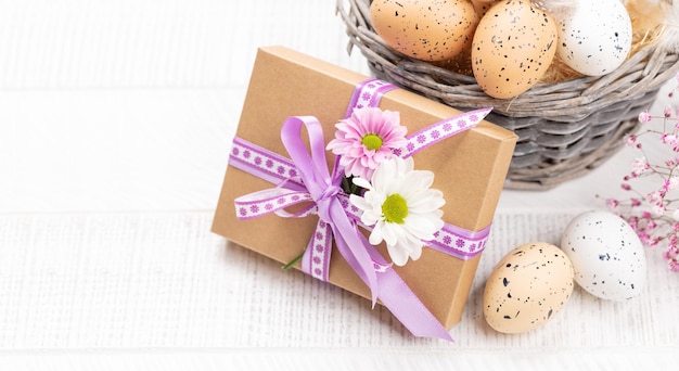 Caja de regalo con flores y canasta de huevos de Pascua