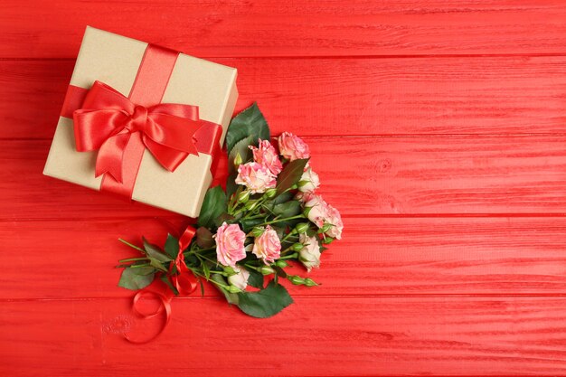 Caja de regalo con flores en mesa de madera